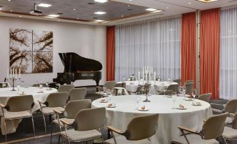 a large dining room with tables and chairs arranged for a group of people to enjoy a meal together at Steigenberger Airport Hotel Amsterdam