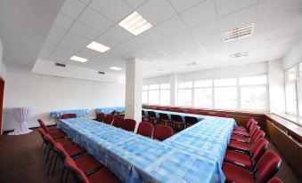 a large conference room with multiple tables and chairs arranged in a semicircle , providing seating for a group of people at Hotel Regent