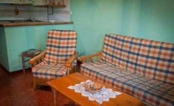 a living room with two couches and a coffee table , all covered in plaid fabric at Viviendas Rurales Traldega