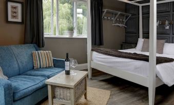 a cozy bedroom with a bed , couch , and dining table , all decorated in white and brown colors at Beck Hall