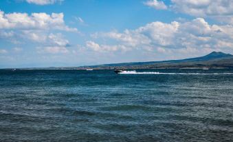 a body of water , possibly a lake or ocean , with a boat traveling through it at Garden Inn Resort Sevan