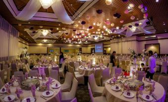 a well - decorated banquet hall with multiple tables and chairs set up for a formal event at Palm Beach Resort & Spa