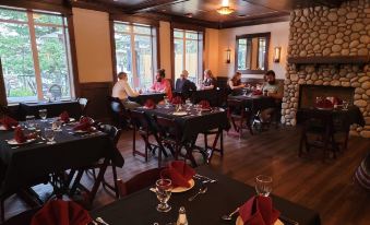 a restaurant with tables set up for dining , people sitting at the tables , and a fireplace in the background at Kilmorey Lodge