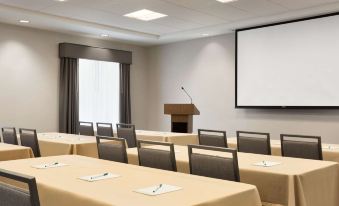 a conference room with chairs arranged in rows and a projector on the wall , providing audio visual entertainment at Homewood Suites by Hilton Salt Lake City Draper