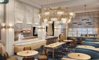 a modern restaurant with wooden tables and chairs , a counter , and a person standing near the counter at Canopy by Hilton Philadelphia Center City