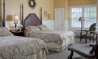 a room with two beds , one on the left and one on the right side of the room at Colonial Inn