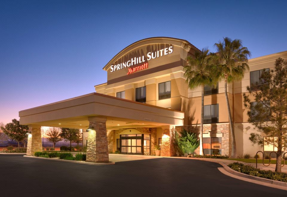 "a large , modern hotel building with a curved design and the name "" springhill suites "" lit up at night" at SpringHill Suites Thatcher