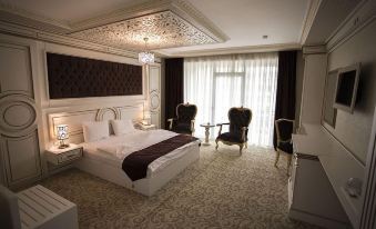 a luxurious bedroom with a large bed , two chairs , and a rug on the floor at Opera Hotel