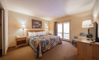 a hotel room with a bed , two lamps , and a sliding glass door leading to a balcony at Telemark Northwoods Lodging