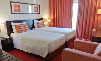 a hotel room with two beds , a couch , and a window covered by pink curtains at Hotel Monaco