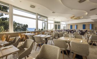 a large dining room with many tables and chairs arranged for a group of people to enjoy a meal at Hotel Histrion