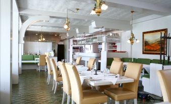 a modern , well - lit restaurant with white tablecloths and gold pendants , creating a warm and inviting atmosphere at Stern