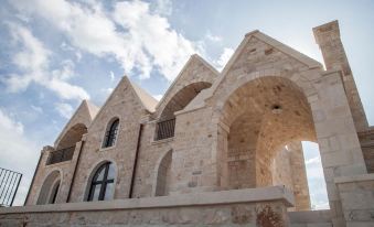 a stone building with an arched entrance , surrounded by a fence and located on a hillside at Ottolire Resort