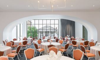 a large dining room with multiple tables and chairs arranged for a group of people to enjoy a meal at Quirk Hotel Charlottesville