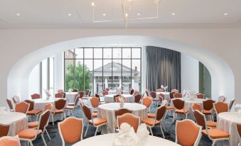a large dining room with multiple tables and chairs arranged for a group of people to enjoy a meal at The Doyle Hotel