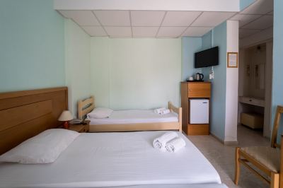 a hotel room with two beds , a nightstand , and a small refrigerator , all neatly arranged at Hotel Summery