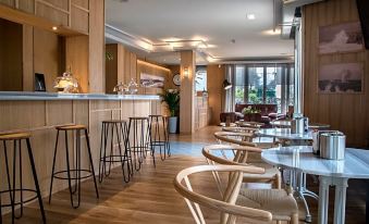 a modern restaurant with wooden furniture , including tables and chairs , and a bar area with stools at Hotel Don Pepe