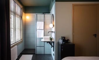 a modern bathroom with a blue and white color scheme , equipped with a sink , toilet , and shower at Mr Lewis Zandvoort