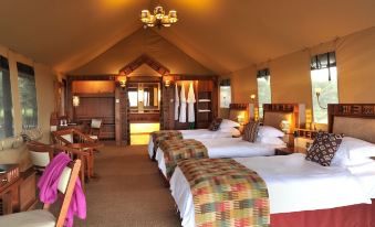 a large , well - lit room with multiple beds and wooden furniture , including a bunk bed and an open door at Sweetwaters Serena Camp
