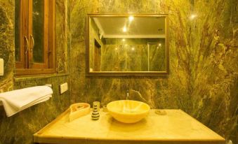 a bathroom with a marble sink and mirror , along with a toilet and a sink at Ocean Suite