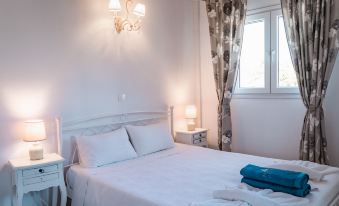 a clean , well - organized bedroom with a white bed and curtains , along with a tv mounted on the wall at Apartment Sofia