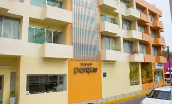 "a large building with a yellow wall and the words "" hotel "" on the side , located on a street corner" at Hotel del Parque