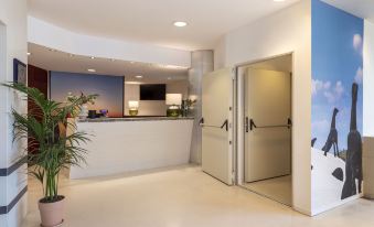 a modern office lobby with a reception desk and a large whiteboard on the wall at B&B Hotel Trapani Crystal