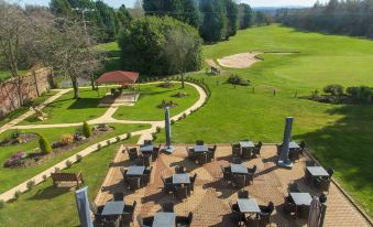 an aerial view of a golf course with multiple umbrellas and tables set up for outdoor dining at The Telford Hotel, Spa & Golf Resort