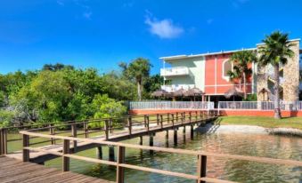 a wooden dock extending into a body of water , with a building in the background at Legacy Vacation Resorts-Indian Shores