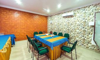 a conference room with a table , chairs , and a stone wall is set up for a meeting at Casino Hotels Ltd