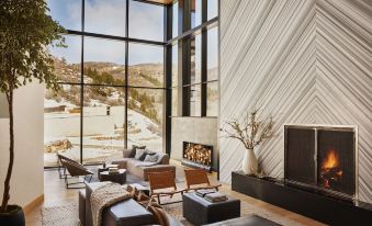 a modern living room with a large window and a fireplace , featuring comfortable seating arrangements at The Lodge at Blue Sky, Auberge Resorts Collection