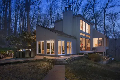 Luxurious midcentury modern glass house in the woods, chefs kitchen & great art