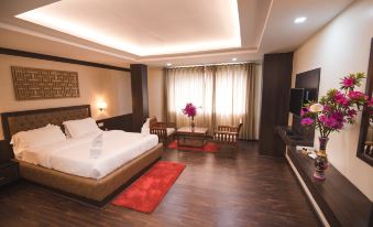 a large bedroom with a king - sized bed , a flat - screen tv , and a red rug on the floor at Sleeping Buddha