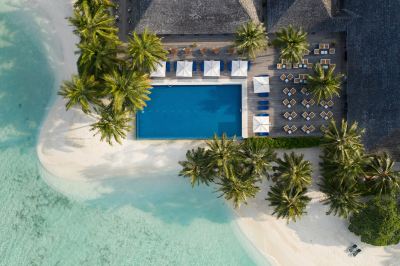an aerial view of a resort with a pool surrounded by palm trees and white sand at Vilamendhoo Island Resort & Spa
