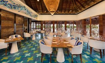 a large dining room with blue and white tile flooring , several tables and chairs arranged for a group of people to enjoy a meal at Chable Maroma