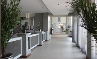 a hotel lobby with white marble floors and walls , creating a warm and inviting atmosphere at Grand Palace Hotel Mzuzu