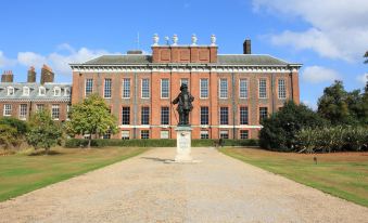 a brick building with a statue of a man in front of it , surrounded by trees at The Windmill