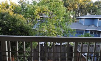 a balcony overlooking a yard with trees and a house in the background , creating a serene and peaceful atmosphere at Chips and Salsa