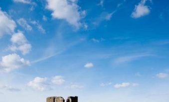 a stone tower stands in a field of purple flowers with a clear blue sky above at The Horseshoe Country Inn