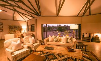 a spacious living room with wooden furniture , including a couch , chairs , and a coffee table at Old Drift Lodge