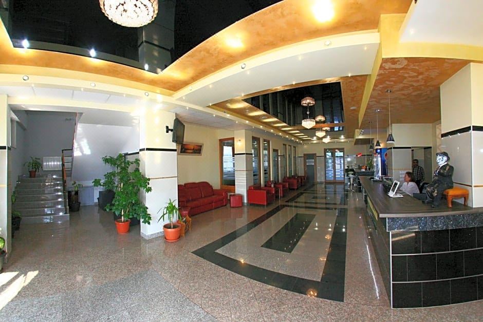 a large , modern hotel lobby with multiple couches and chairs , as well as potted plants and a bar area at Hotel Seneca