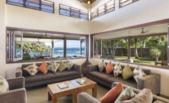 a spacious living room with a large sectional couch and a view of the ocean at Eratap Beach Resort