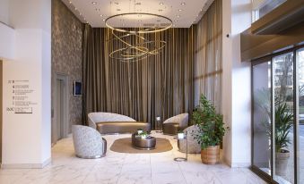 a modern hotel lobby with a large chandelier hanging from the ceiling , creating an elegant atmosphere at Hôtel du Port