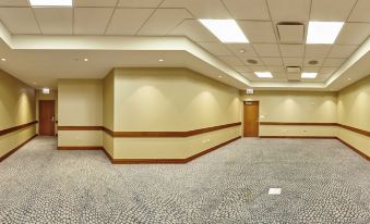 a large , empty room with beige walls and wooden paneling , decorated with recessed lighting and a door at The Westin Chicago North Shore