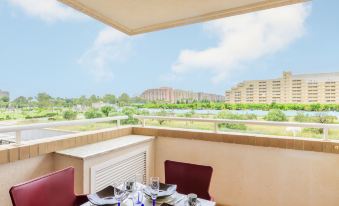 a table with plates and silverware is set on a balcony overlooking a city skyline at Blue