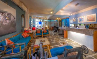 a modern and stylish hotel lobby with blue couches , a wooden bar , and a reception desk at Apollonia Hotel Apartments