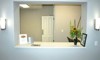 a hallway with a white counter , a vase of sunflowers , and framed pictures on the wall at Cornerstone Inn