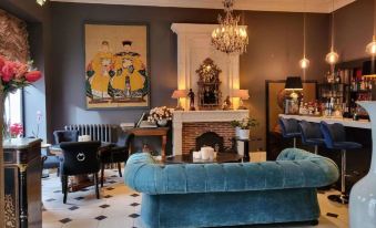 a living room with a blue couch , black chairs , and a chandelier hanging from the ceiling at Hotel Vendome, BW Signature Collection
