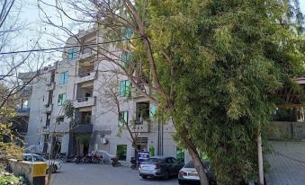 a city street with a building on the left side and a car parked in front of it at Parkway Apartments