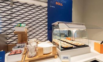"a buffet table with various food items , including pastries and a sign that says "" this is how we roll .""." at Home2 Suites by Hilton Ogden
